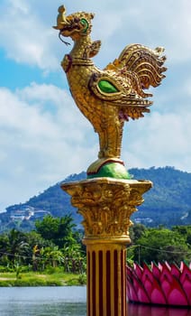 Row of golden rooster statues in buddhist temple