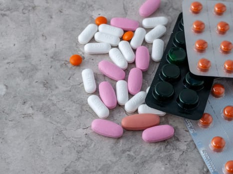 multicolored medical pills and packs of pills on a table.