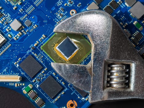Computer repair concept, wrench on motherboard close up