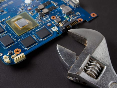 Computer repair concept, wrench on motherboard close up