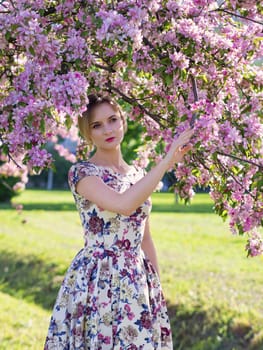 Young beautiful blonde woman in blooming garden. Bride.