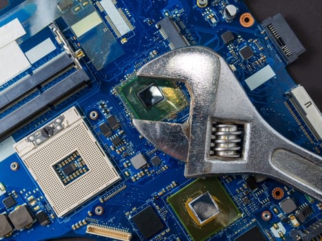 Computer repair concept, wrench on motherboard close up