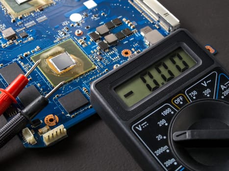 Multimeter test, electronic board of digital device with components. Troubleshoot electronic device. Computer and mobile device repair concept