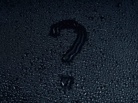 question mark written on a surface made of drops on a black background.