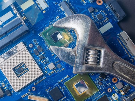 Computer repair concept, wrench on motherboard close up
