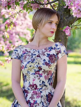 Young beautiful blonde woman in blooming garden. Bride.