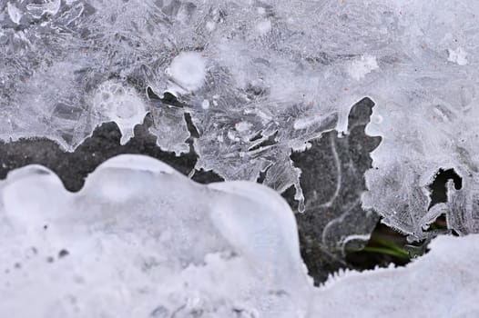 Frozen stream. Beautiful winter nature background. Frost, ice and snow in the winter.