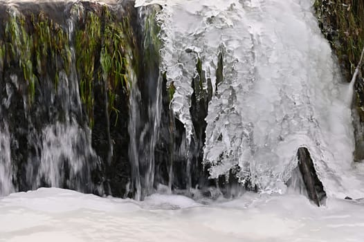 Frozen stream. Beautiful winter nature background. Frost, ice and snow in the winter.