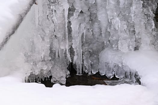 Frozen stream. Beautiful winter nature background. Frost, ice and snow in the winter.