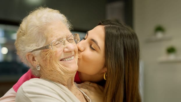 Photo of a granddaughter kissing her grandmother with lots of love