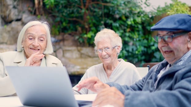 Close-up photo of seniors of a geriatric waving during a video call with laptop