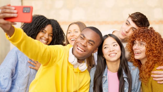 Cool african man taking a selfie with multi-ethnic friends int he street