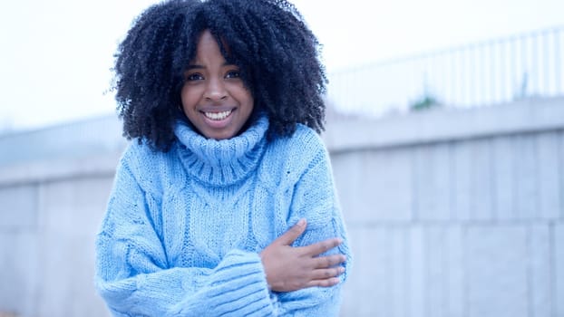 Young african woman gesturing cold in the street