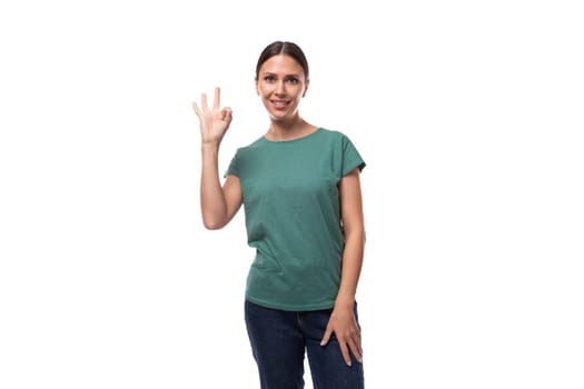 well-groomed slender young brunette woman dressed in a green T-shirt smiling affably.