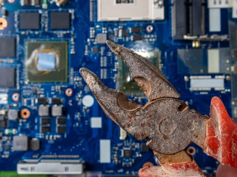 Computer repair concept. Old rusty passages on a blue laptop motherboard. The concept of unskilled work