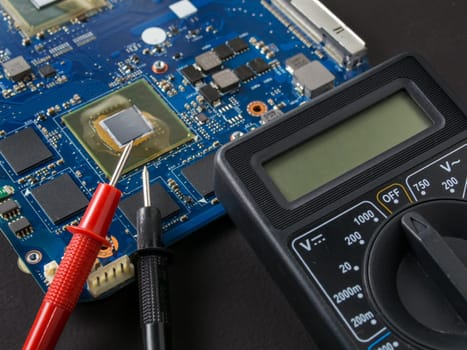 Multimeter test, electronic board of digital device with components. Troubleshoot electronic device. Computer and mobile device repair concept