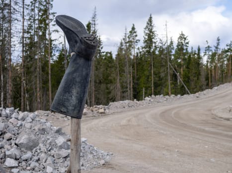 Rubber boot on a stick, bad road signpost.
