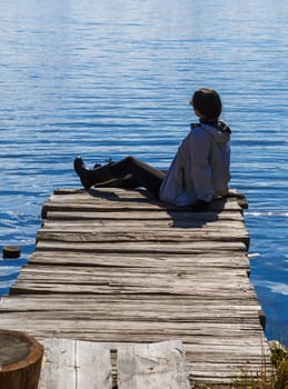 girl on a wooden pier by the lake
