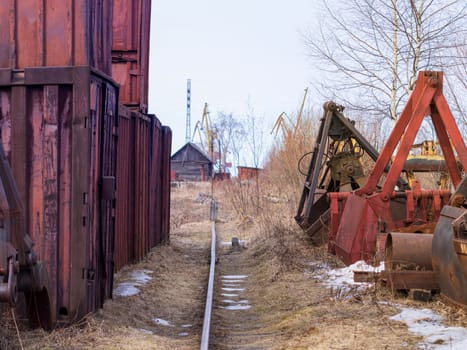 Old rusty abandoned building gantry crane on rusty rails. Abandoned container loading construction warehouse. Dead Zona.