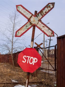 Old and rusty railroad sign with stop letters.