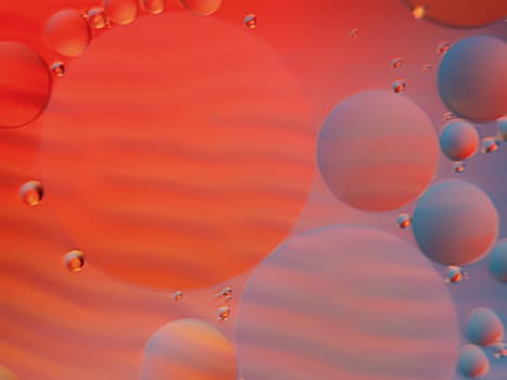 Abstract oil spots in motion on water on blurred yellow background. Photo with small depth of field.