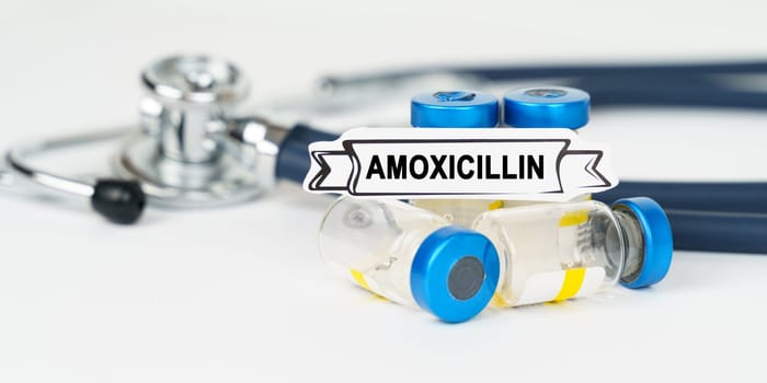 Medical concept. On the table there is a stethoscope, injections and a sign with the inscription - Amoxicillin