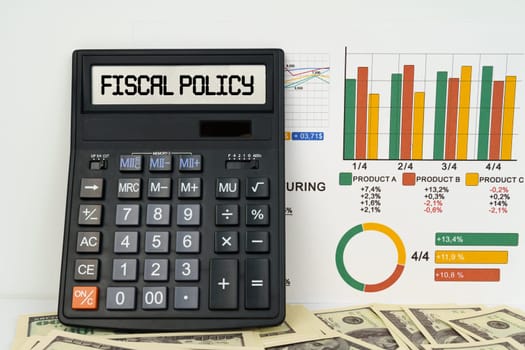 Business concept. On the table are financial reports, dollars and a calculator with the inscription - Fiscal policy