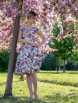 Young beautiful blonde woman in blooming garden. Bride.