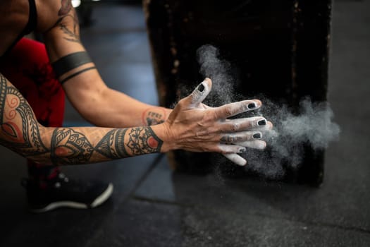 Close-up photo of a female strong hands with magnesium clasping ready to weightlifting in a gym