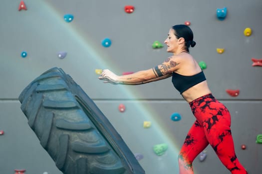 Side view of an energetic mature woman working out with a wheel in a gym