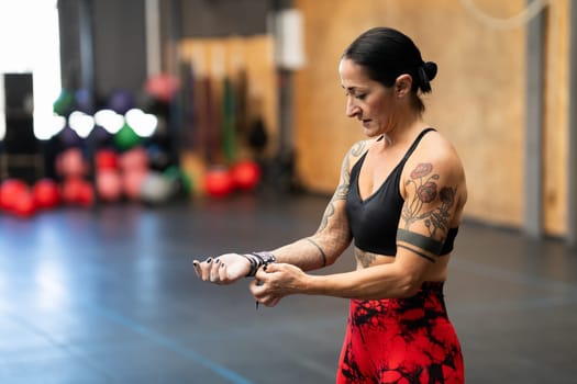 Horizontal photo with copy space of a mature woman protecting her wrist before training in a gym