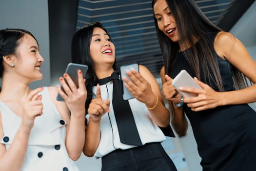 Three women friends having conversation while looking at mobile phone in their hands. Concept of social media, gossip news and online shopping. uds