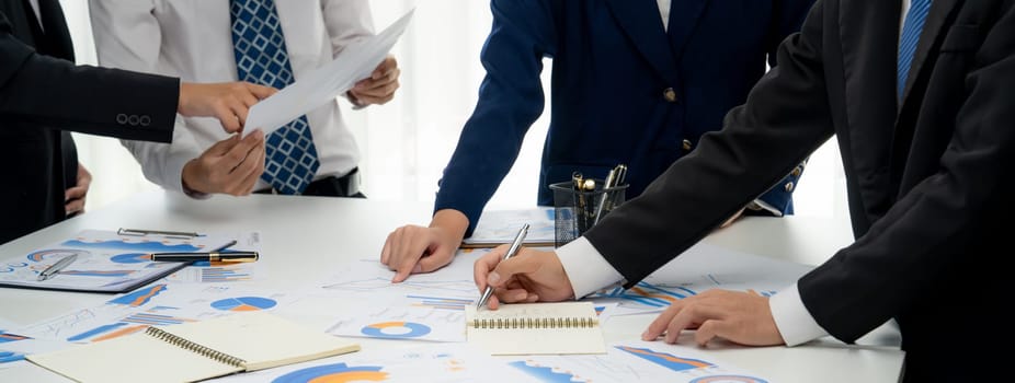 Business people in group meeting in formal attire share idea discussing report for company profit in creative workspace for start up business shot in close up view on group meeting table . Oratory .