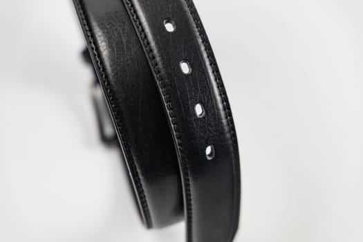 Long and wide black leather belt with few small holes and metallic big buckle