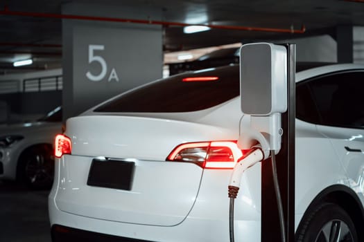 EV electric car recharge at shopping center parking lot charging in downtown city showing urban sustainability lifestyle by green clean rechargeable energy of electric vehicle innards