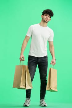 Man, on a green background, full-length, with bags.