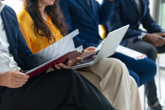 Diversity candidates waiting for job interview. Intellectual. Low section crop of interviewees sitting on a chair while preparing their document and themselves for presentation. Intellectual.