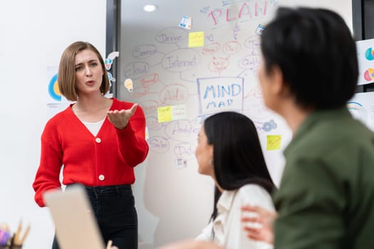 Young beautiful caucasian businesswoman presenting marketing strategy by using mind map, graph while answering questions with confident. Teamwork, brainstorming, discussing concept. Immaculate.