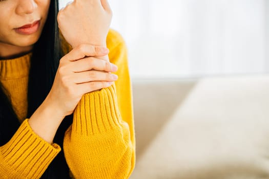 Illustrating hand pain, Woman holds her achy wrist indicating Carpal Tunnel Syndrome or discomfort. Emphasizing inflammation symptoms and discomfort in the hand's anatomy. Health care concept