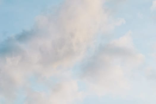 Background of blue sky with pale pink clouds at sunset