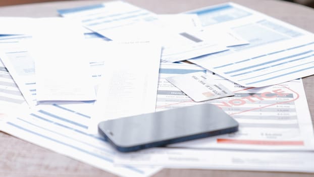 Piles of invoice bills or mortgage notification papers as modern financial over spending lifestyle from use of credit card and online payment from wallet protected by prim cyber security software