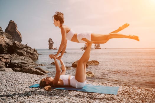 Woman sea yoga. Back view of free calm happy satisfied woman with long hair standing on top rock with yoga position against of sky by the sea. Healthy lifestyle outdoors in nature, fitness concept.