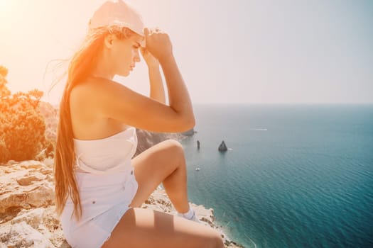 Woman travel sea. Young Happy woman in a long red dress posing on a beach near the sea on background of volcanic rocks, like in Iceland, sharing travel adventure journey