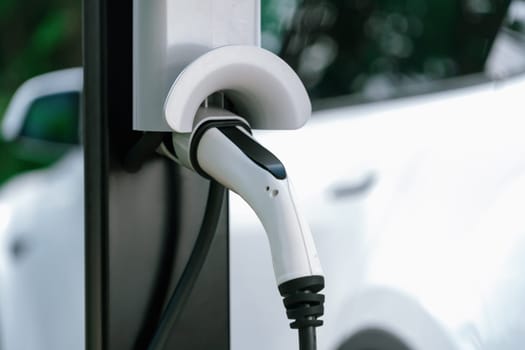 Closeup EV charging station with electric charger plug connected to charging platform power sauce. Alternative clean and sustainable energy for eco-friendly EV car for better future. Synchronos