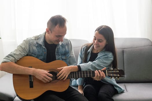 Happy family Father and daughter playing guitar. Father's day. High quality photo