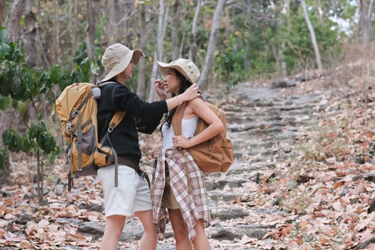 An Asian couple spends their free time on a hiking trip together..