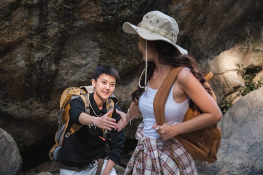 An Asian couple spent their vacation hiking along nature trail, visiting waterfall and enjoying forest views together..