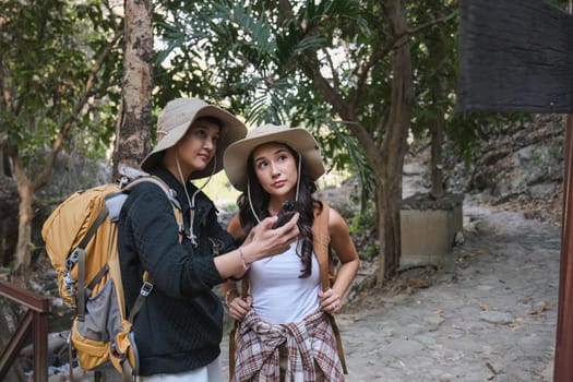 Asian couple hiking in nature Studying the hiking route following the signs..