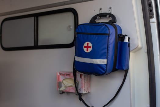 Moscow, Moscow region, Russia - 03.09.2023:A blue medical bag with a red cross and emergency equipment mounted inside an ambulance