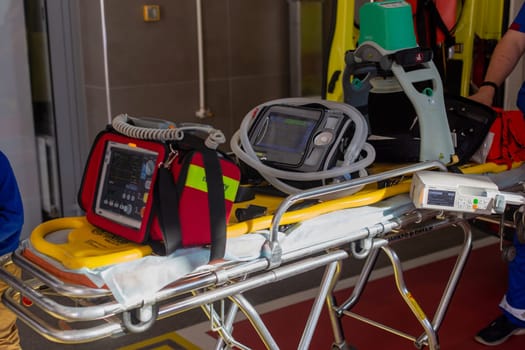 Moscow, Moscow region, Russia - 03.09.2023:Diverse emergency medical devices, including a monitor and a defibrillator, mounted on a stretcher in an ambulance.